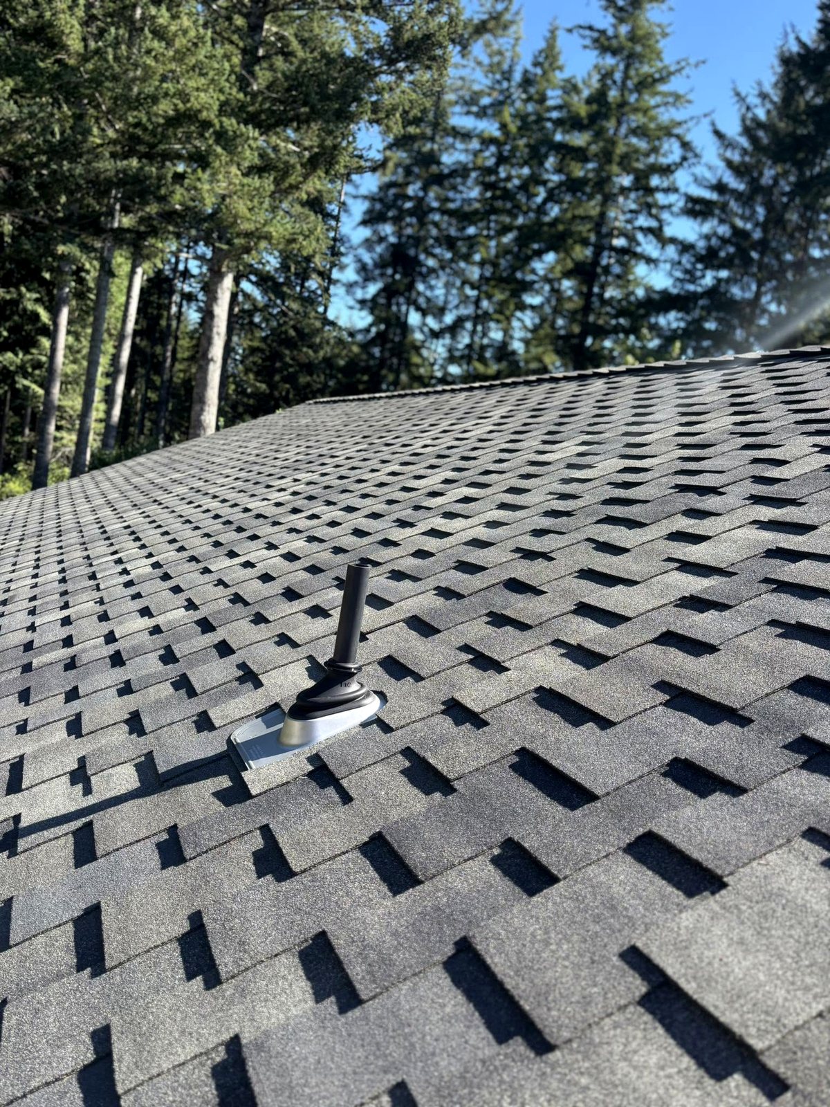 Close detail of a stainless steel Ultimate pipe boot on a finished Malarkey Windsor roof by Pacific Peaks Roofing at Woahink Lake